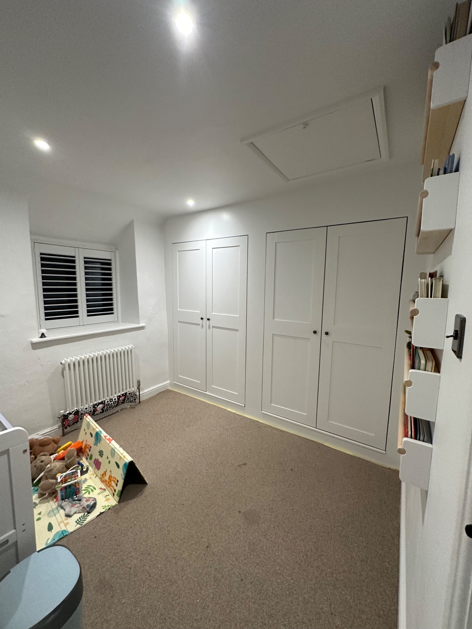 Built-in white wardrobes and storage in a bedroom