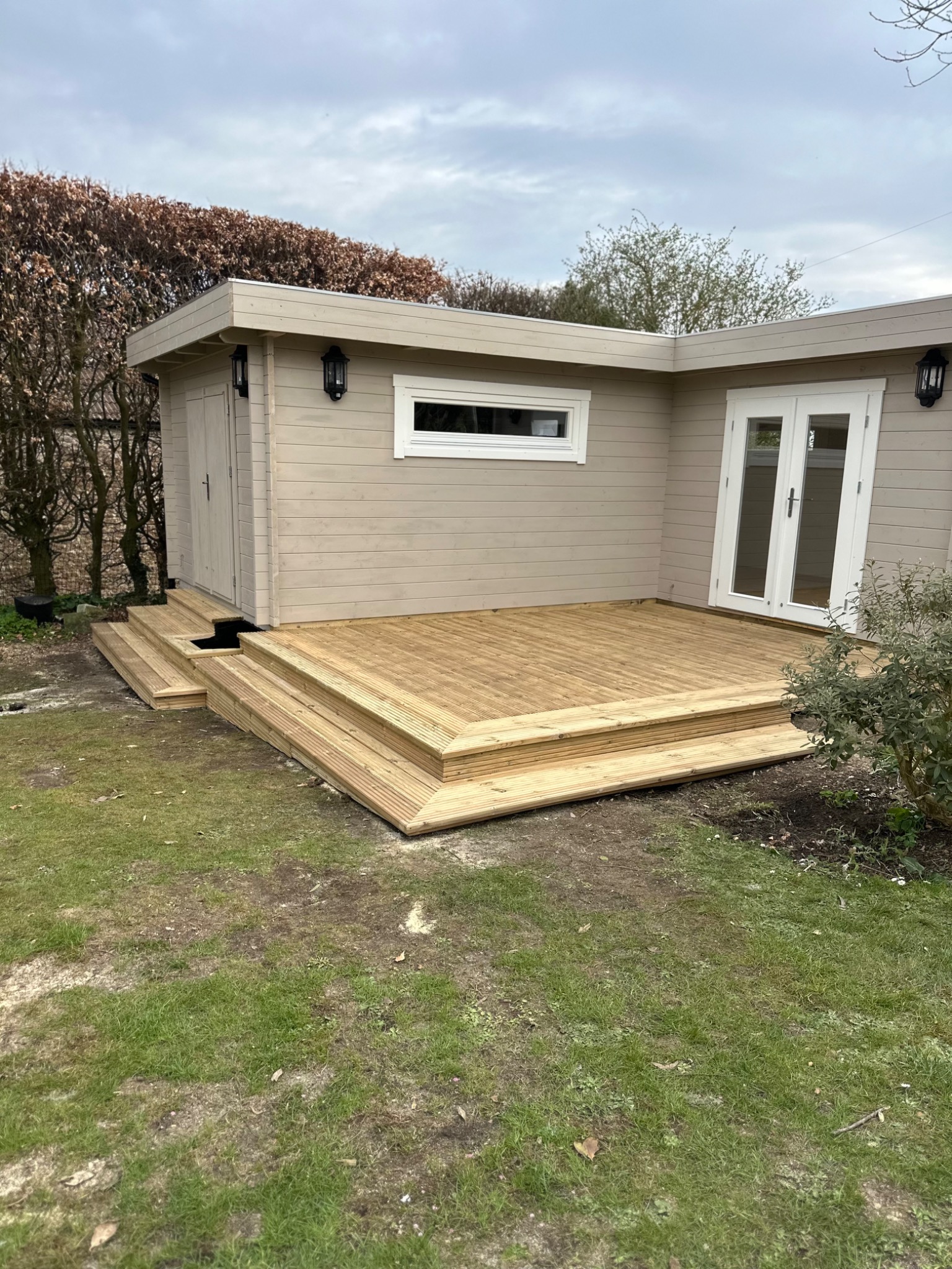 Completed timber decking around a garden room